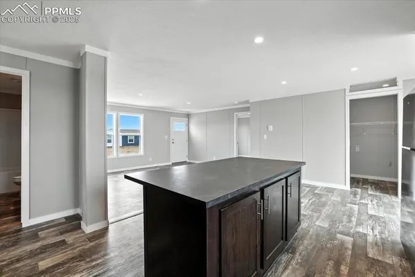 a kitchen with a counter top space and wooden floor