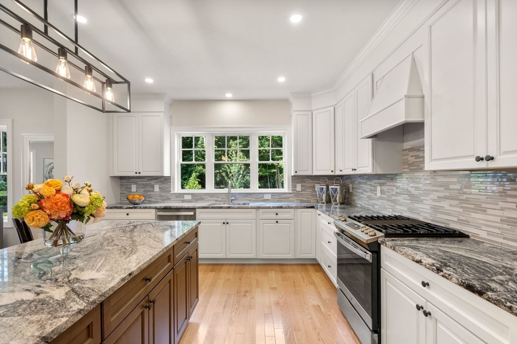 1 Emmeline Path, Unit 1 Wayland, MA 01778 - Photo 6 of 22 a kitchen with stainless steel appliances granite countertop sink stove top oven and cabinets