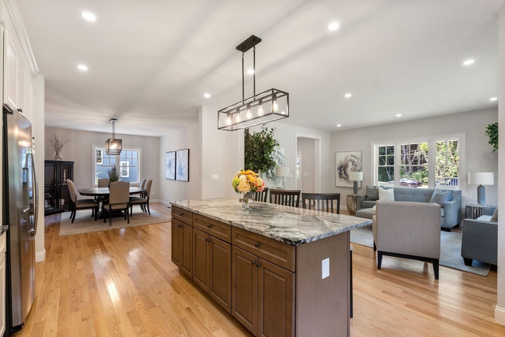 1 Emmeline Path, Unit 1 Wayland, MA 01778 - Photo 7 of 22 a kitchen with counter space dining table and wooden floor