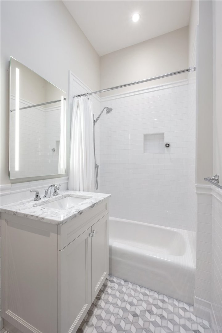 1304 North Ritchie Court Chicago, IL 60610 - Photo 22 of 28 a bathroom with a granite countertop sink a mirror a shower and a bathtub