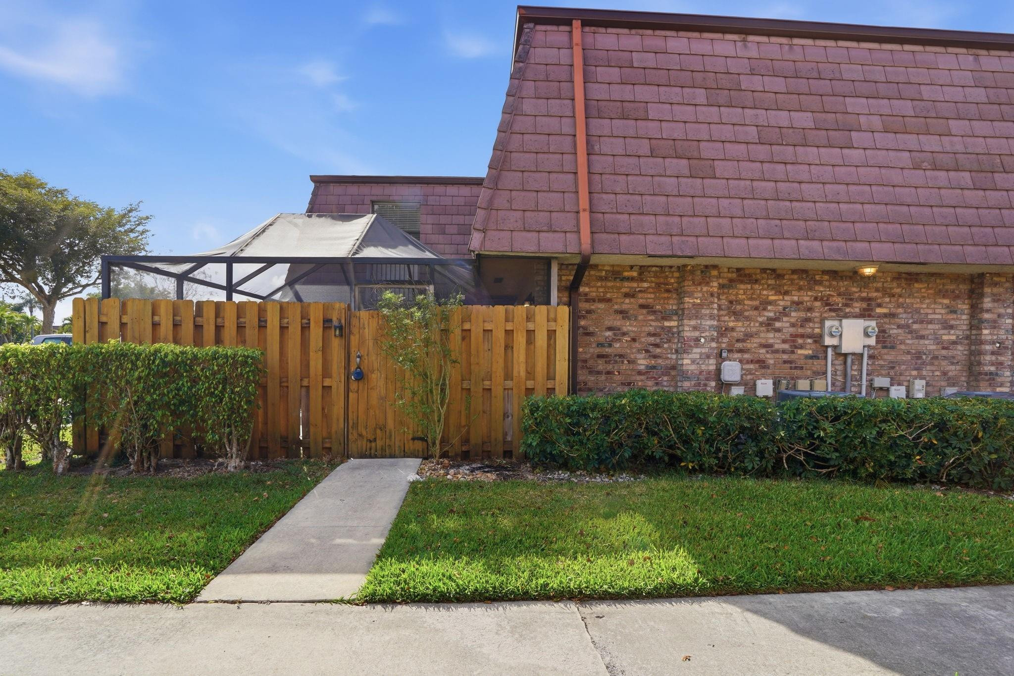7600 Courtyard Run West Boca Raton, FL 33433 - Photo 1 of 34 a view of a brick house next to a yard