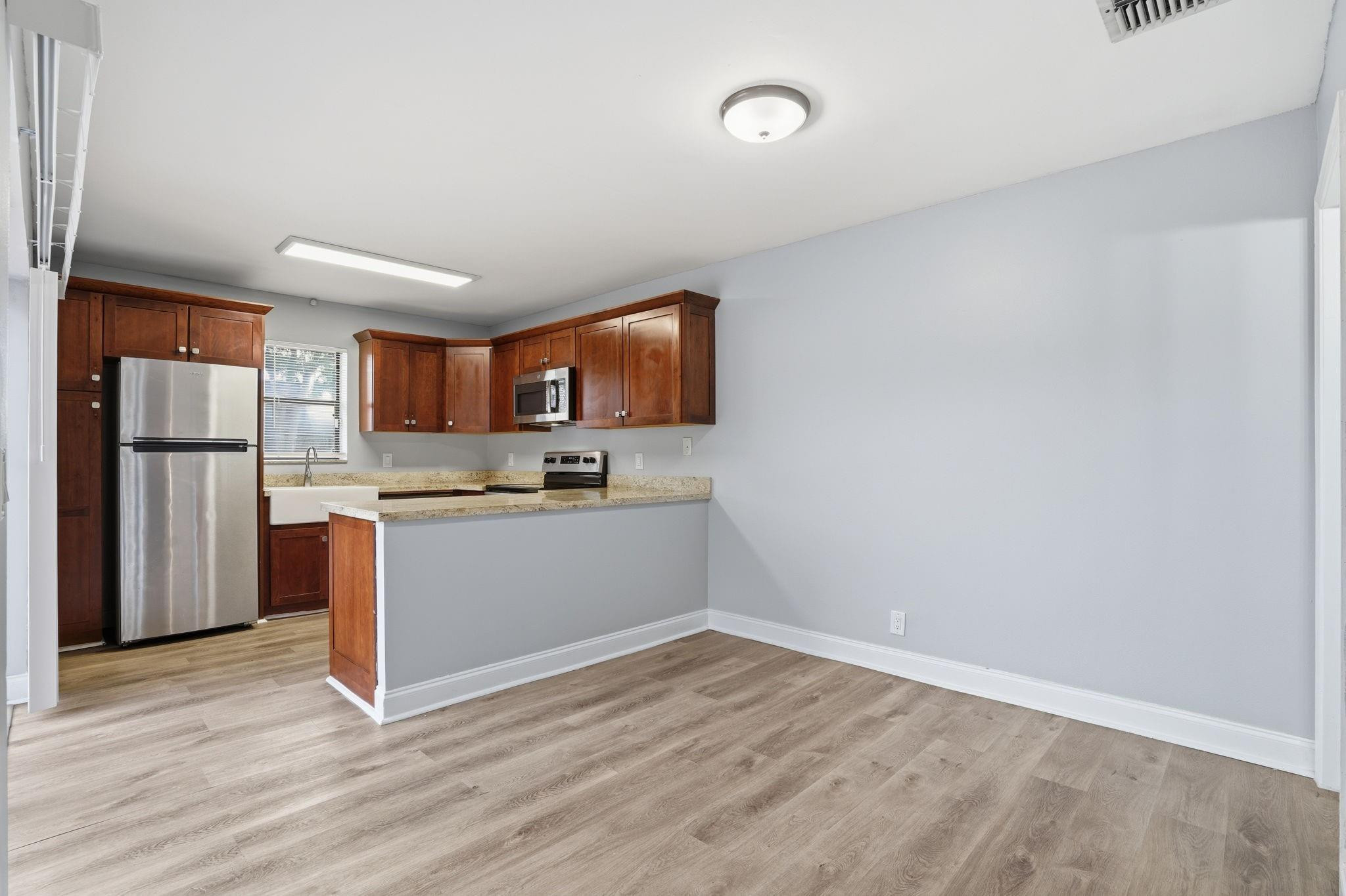 7600 Courtyard Run West Boca Raton, FL 33433 - Photo 14 of 34 a view of kitchen with stainless steel appliances granite countertop a refrigerator sink and wooden cabinets