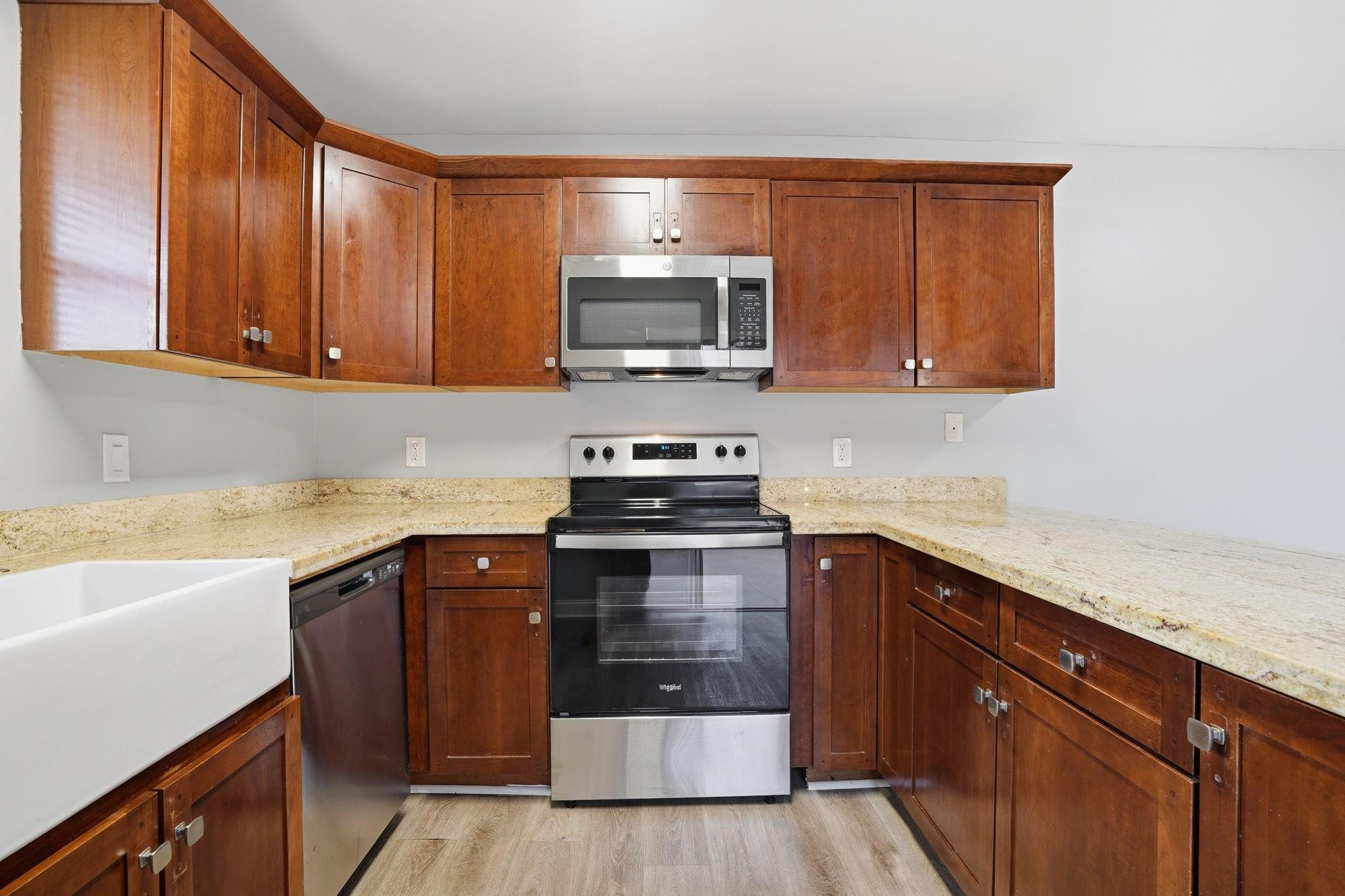 7600 Courtyard Run West Boca Raton, FL 33433 - Photo 15 of 34 a kitchen with stainless steel appliances granite countertop wooden cabinets a stove top oven a sink and dishwasher