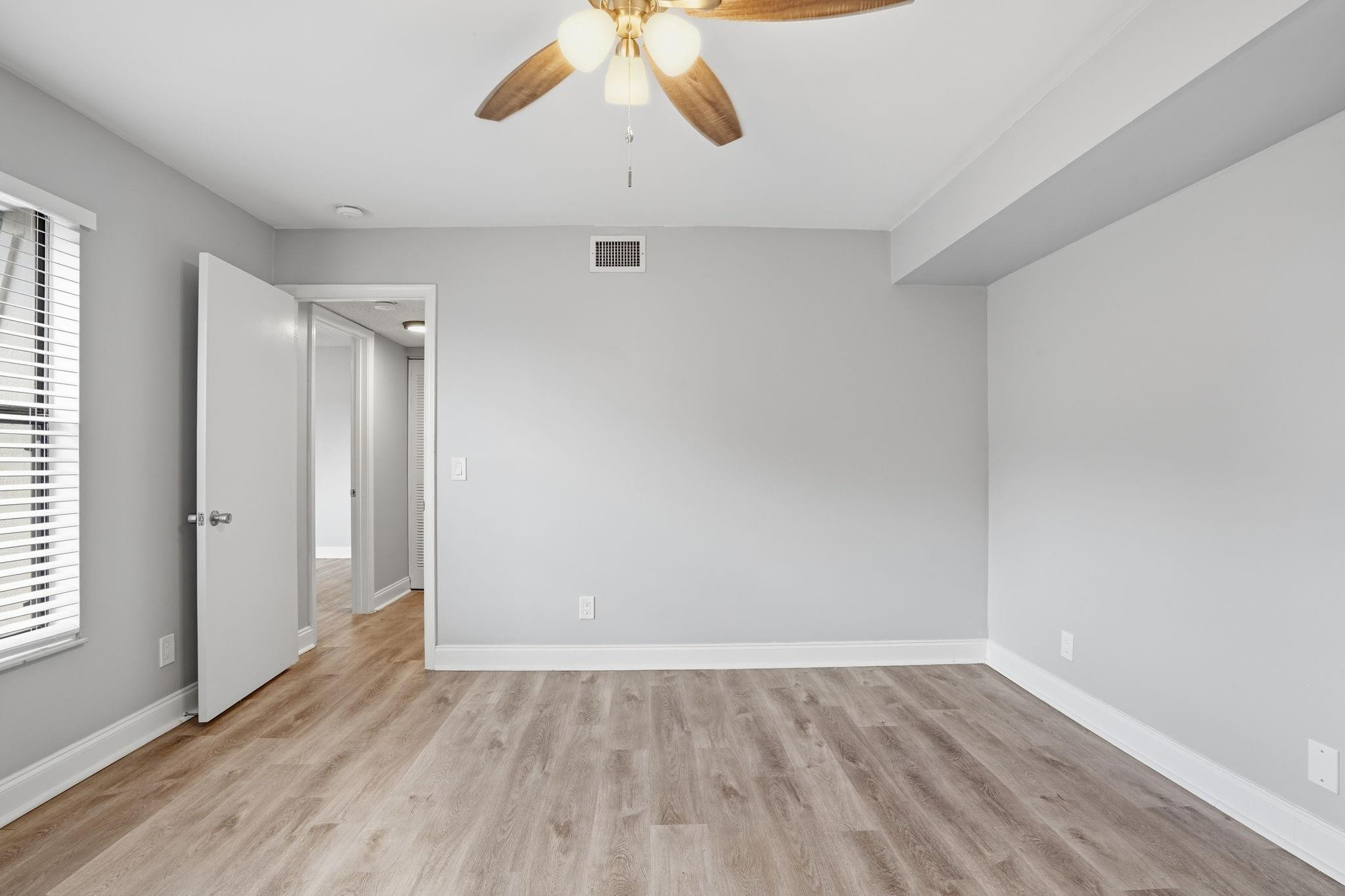 7600 Courtyard Run West Boca Raton, FL 33433 - Photo 18 of 34 an empty room with wooden floor and windows