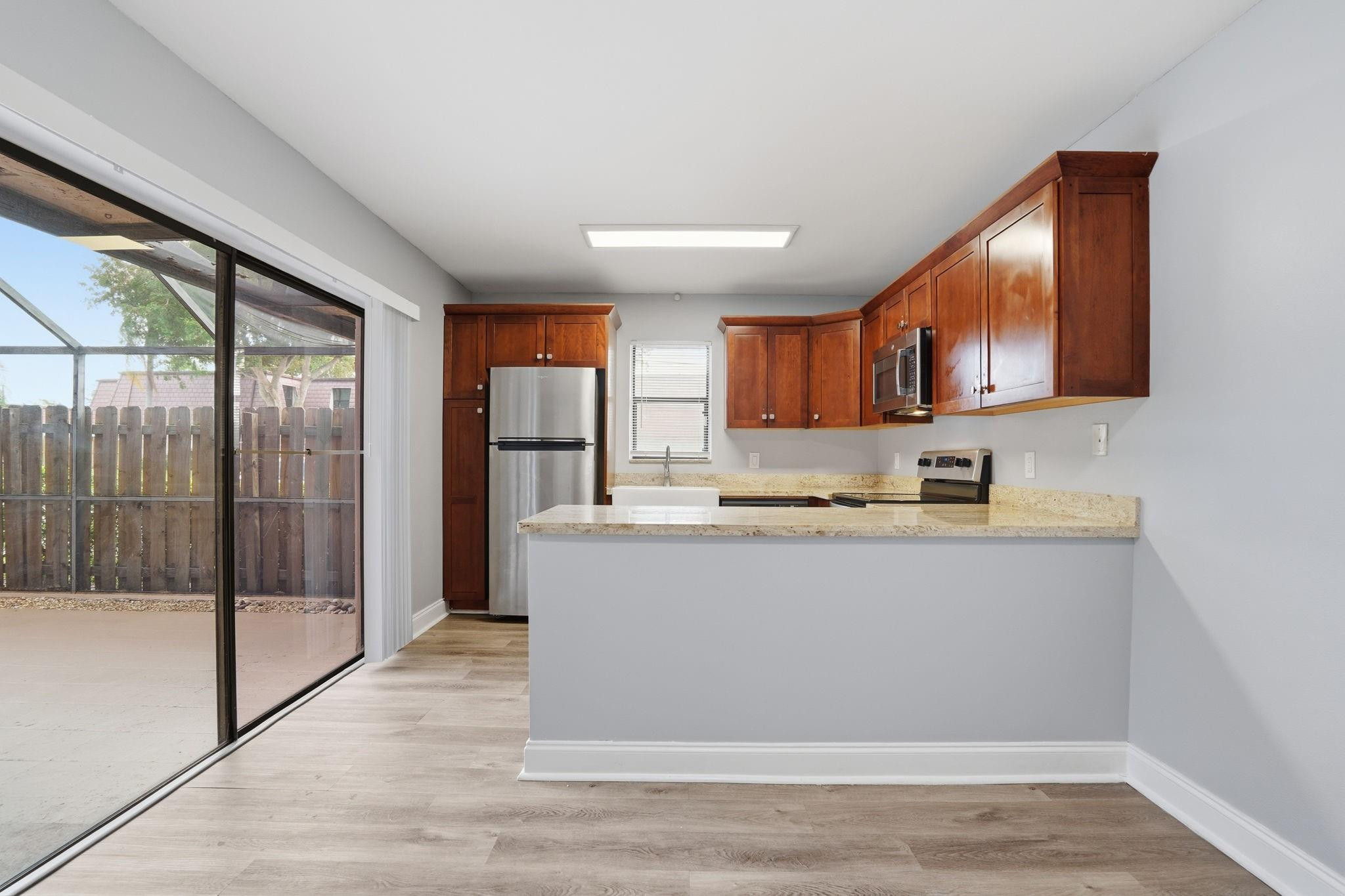 7600 Courtyard Run West Boca Raton, FL 33433 - Photo 6 of 34 a view of kitchen with stainless steel appliances granite countertop a refrigerator stove top oven and sink