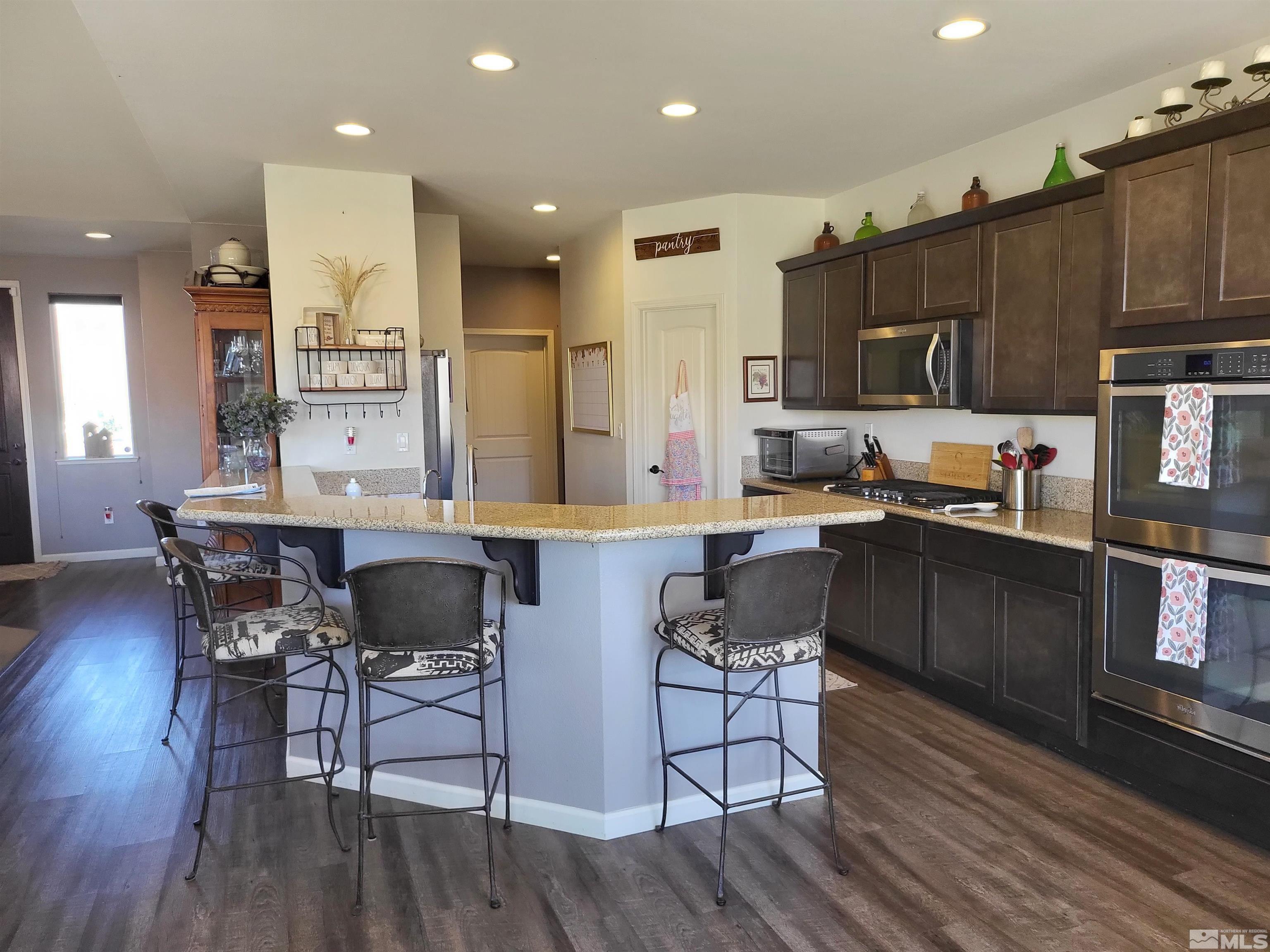200 Pinto Ranch Court Reno, NV 89510 - Photo 9 of 37 a kitchen with granite countertop a table chairs microwave a sink and cabinets