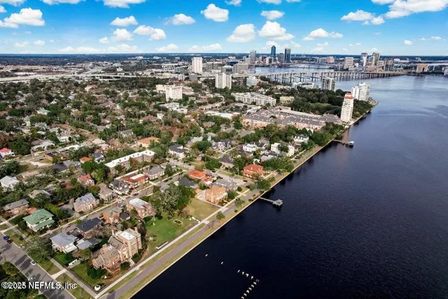 an aerial view of a house with a yard and lake view