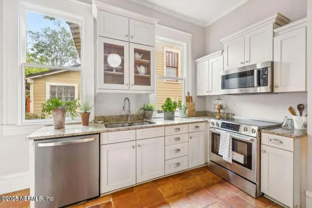a kitchen with stainless steel appliances granite countertop a stove and cabinets