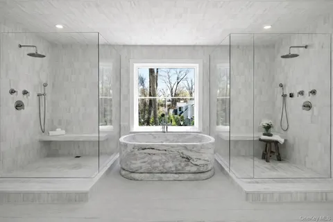 a bathroom with a tub shower and window