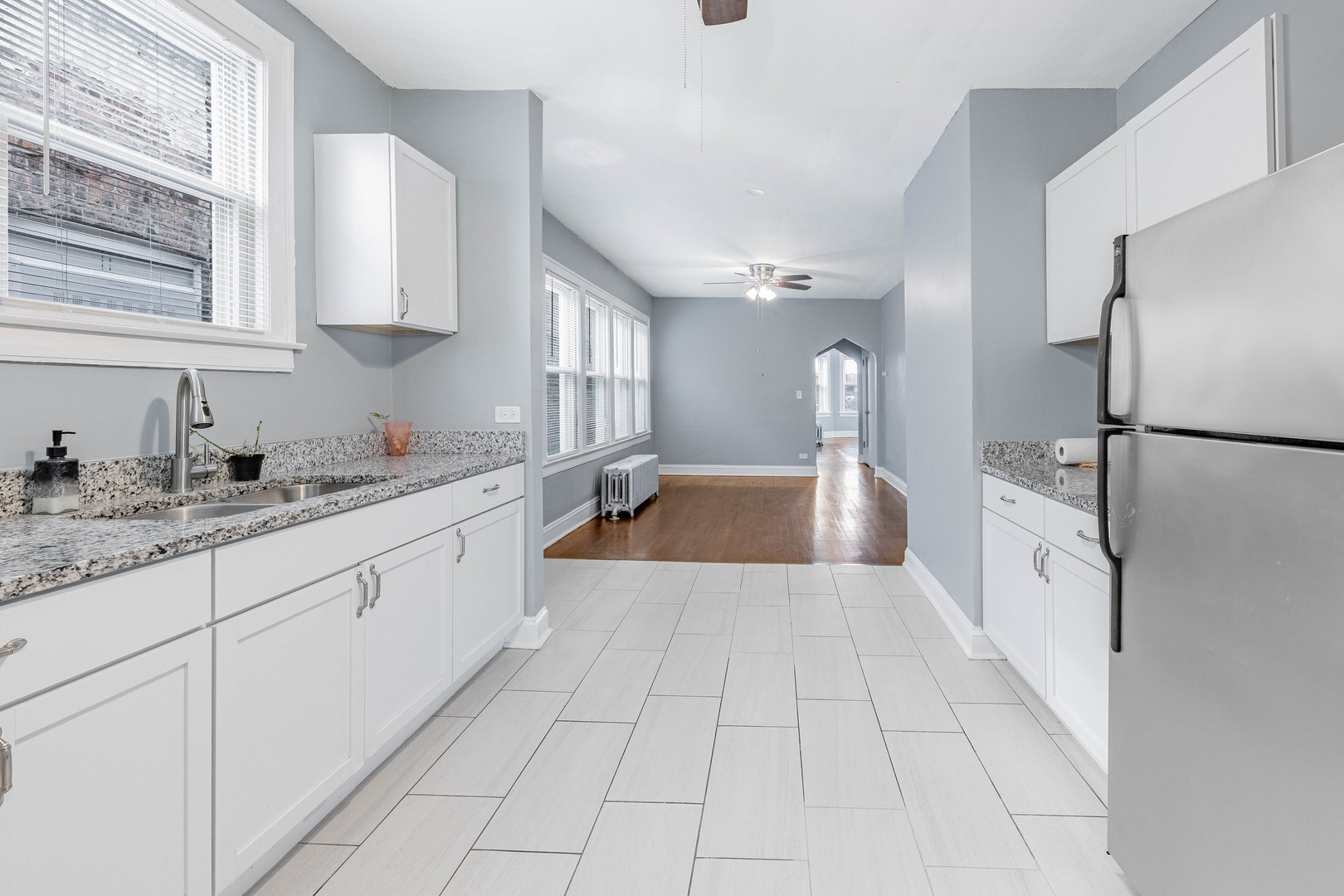 7729 South Laflin Street Chicago, IL 60620 - Photo 13 of 44 a large white kitchen with a sink and dishwasher a refrigerator with white cabinets