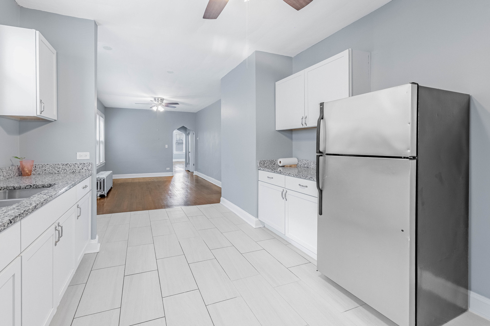 7729 South Laflin Street Chicago, IL 60620 - Photo 14 of 44 a kitchen with white cabinets a refrigerator and a sink