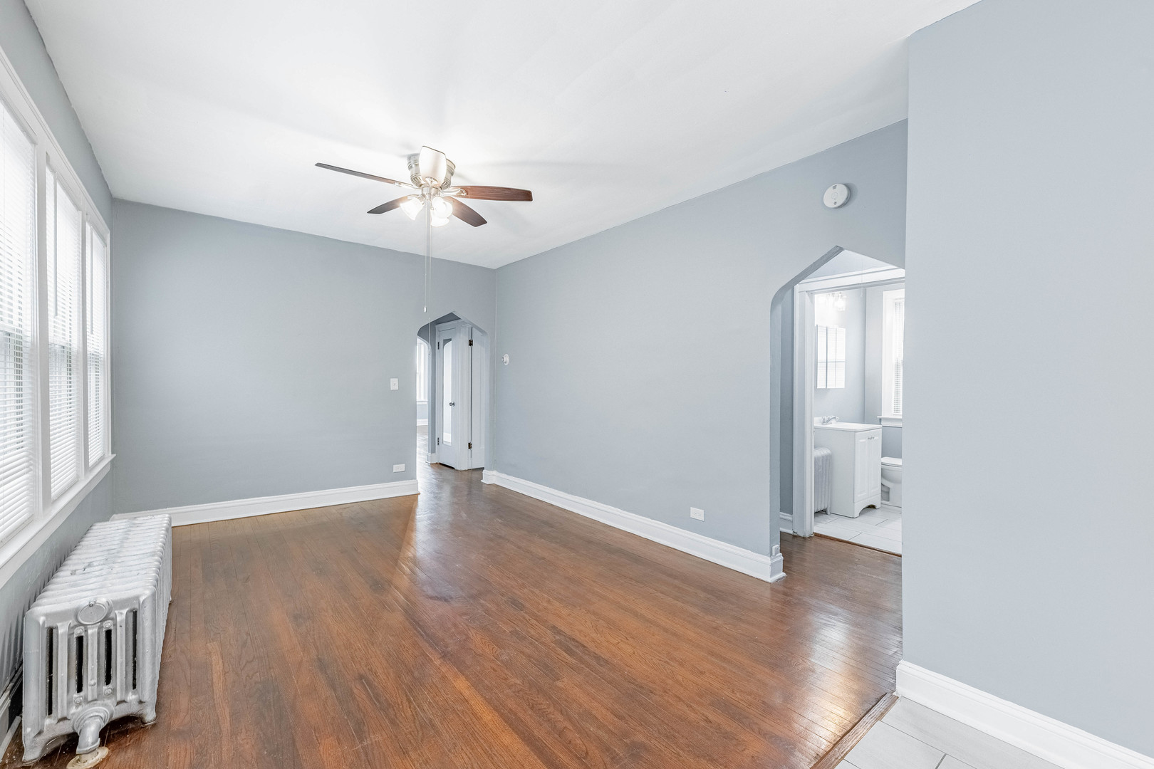 7729 South Laflin Street Chicago, IL 60620 - Photo 17 of 44 an empty room with wooden floor chandelier fan and windows
