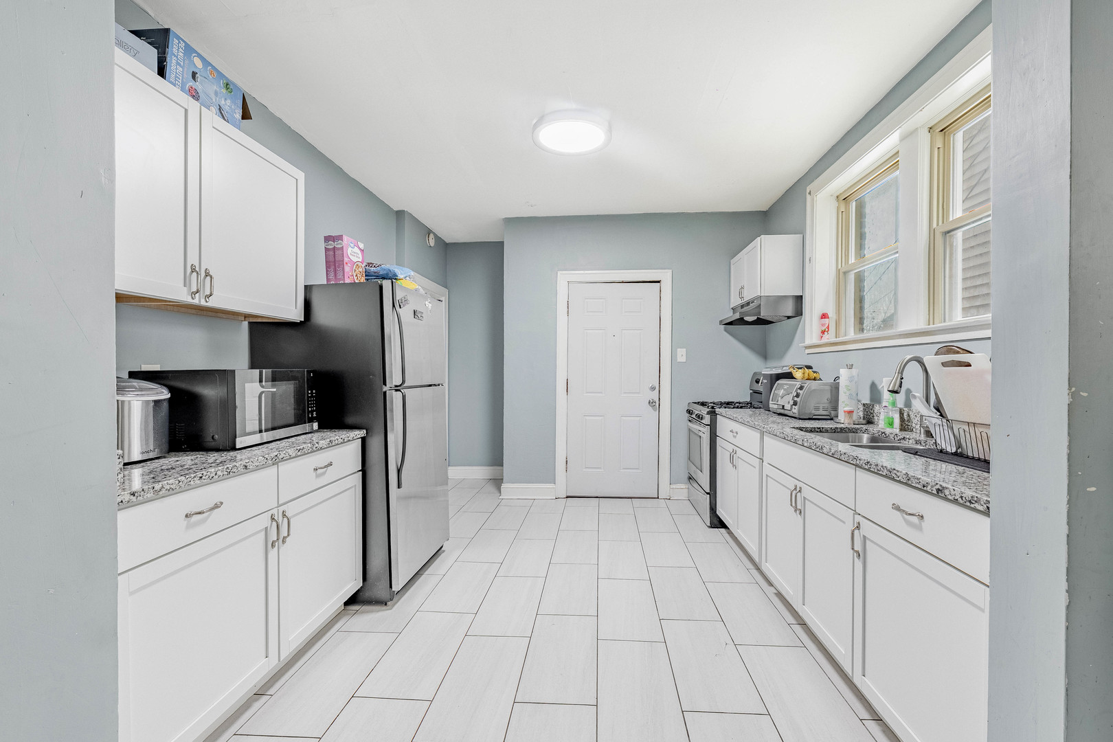 7729 South Laflin Street Chicago, IL 60620 - Photo 32 of 44 a kitchen with white cabinets appliances and sink