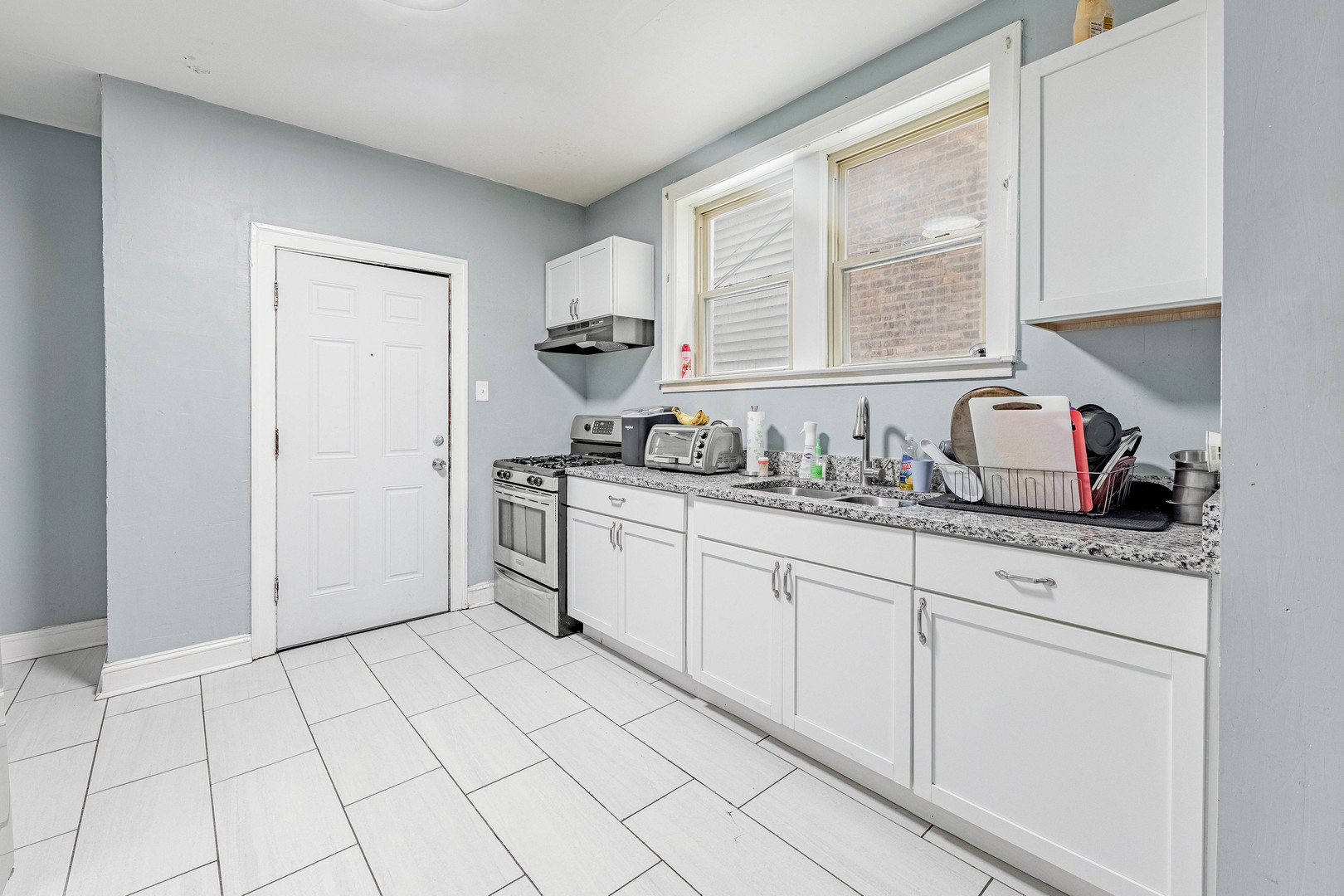 7729 South Laflin Street Chicago, IL 60620 - Photo 33 of 44 a kitchen with white cabinets and appliances