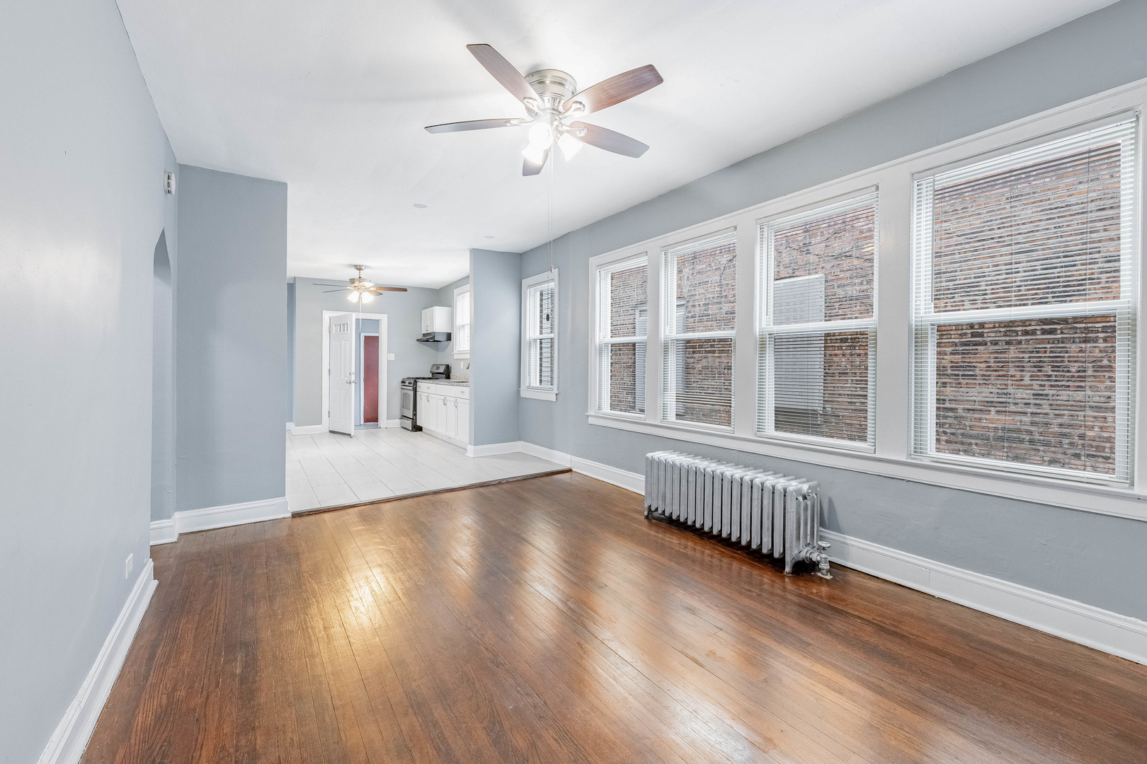7729 South Laflin Street Chicago, IL 60620 - Photo 8 of 44 a view of an empty room with a window and wooden floor