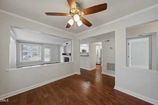 a view of an empty room with window and wooden floor