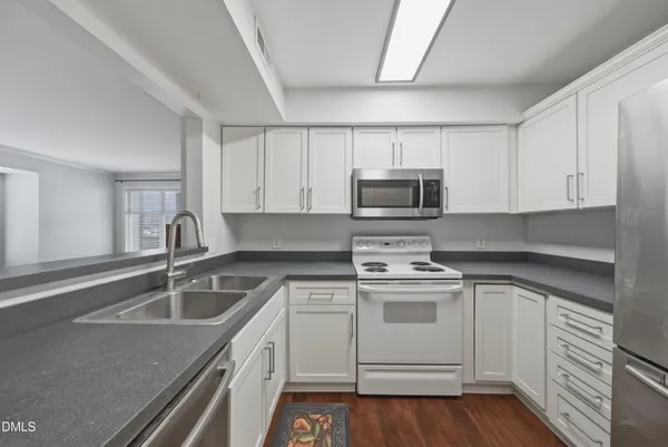 a kitchen with white cabinets stainless steel appliances and sink