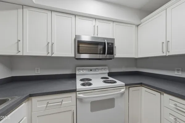 a kitchen with white cabinets and white appliances