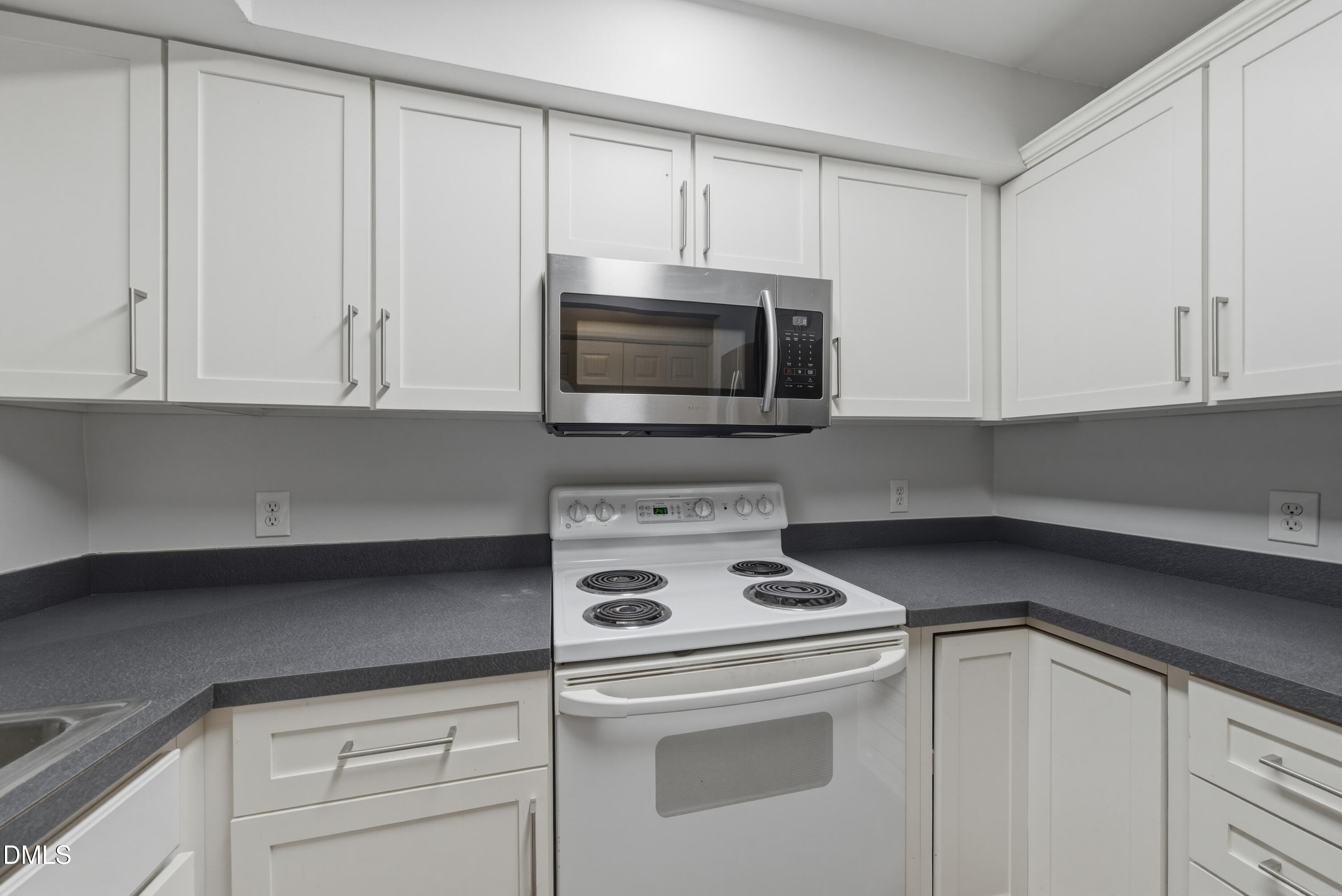 1201 Westview Lane, Unit 105 Raleigh, NC 27605 - Photo 7 of 24 a kitchen with white cabinets and white appliances
