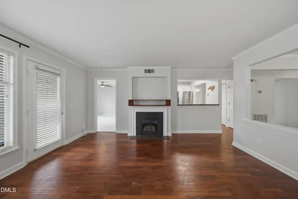a view of a livingroom with wooden floor and a fireplace