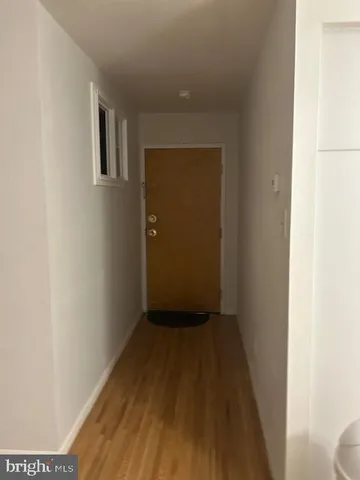 a view of a hallway with wooden floor