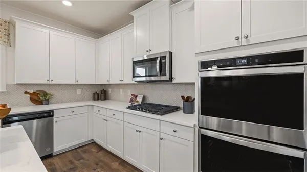 a kitchen with refrigerator and chairs