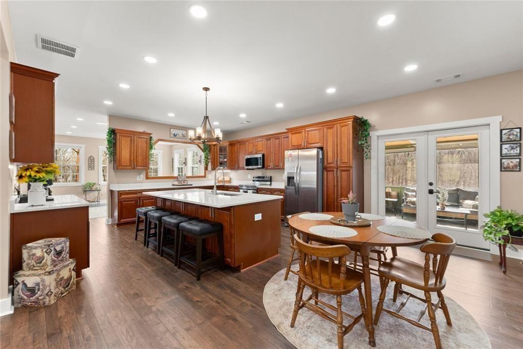 152 Grover Taylor Road Demorest, GA 30535 - Photo 10 of 68 a kitchen with stainless steel appliances granite countertop a refrigerator a stove a sink a dining table and chairs with wooden floor