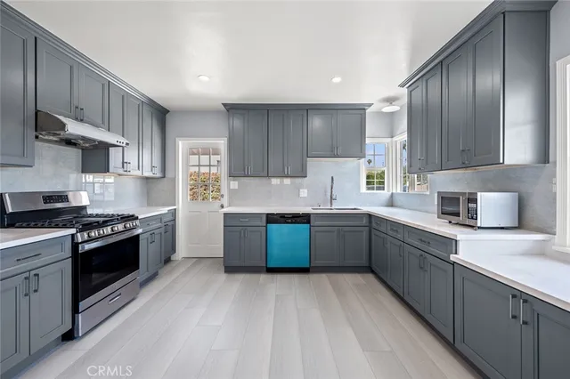 a kitchen with stainless steel appliances granite countertop a stove sink and cabinets