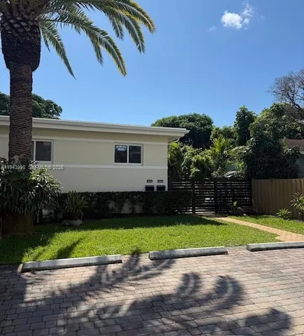 a view of a backyard with plants and palm tree