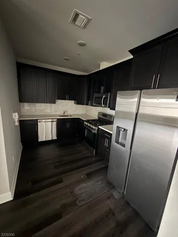 a view of kitchen with sink microwave and refrigerator