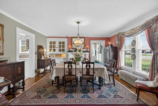 a dining room with furniture window and wooden floor