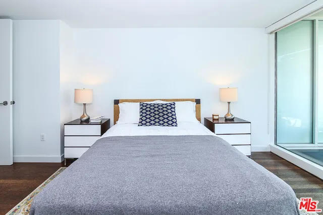 a spacious bedroom with a bed and a lamp