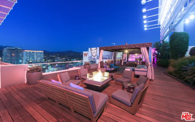 a view of a rooftop deck with couch and chairs