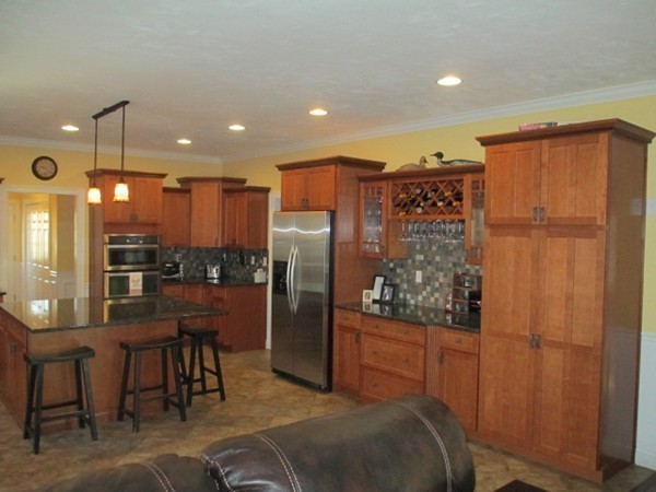 23 Spring Street Rehoboth, MA 02769 - Photo 12 of 27 a kitchen with stainless steel appliances kitchen island granite countertop a refrigerator and a wooden cabinets