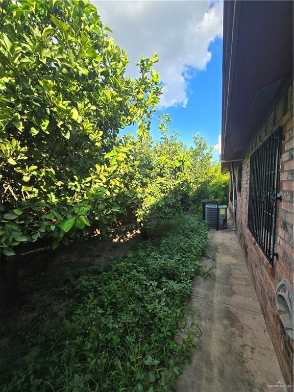 519 East 3rd Street Sullivan City, TX 78595 - Photo 11 of 12 View of home's exterior with brick siding and a central air condition unit
