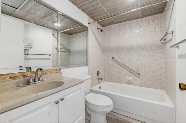 a view of a room with wooden floor closet and windows
