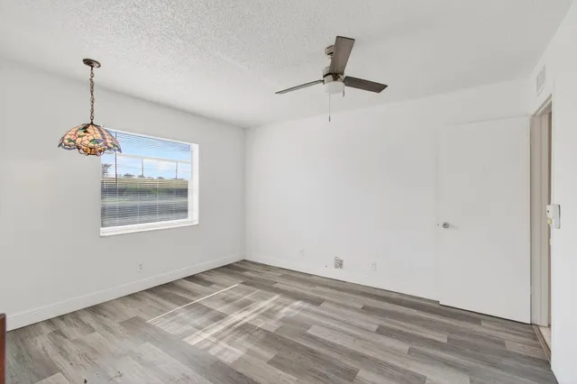 a view of a house with a big yard and potted plants
