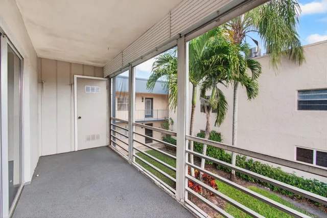 a view of a house with a yard and palm trees