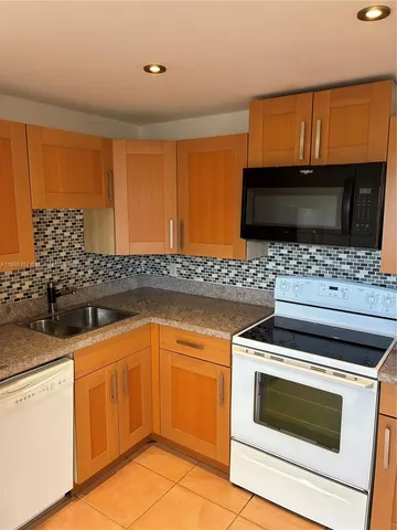 a kitchen with granite countertop a sink and a stove top oven