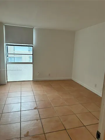 a view of a room with an empty space and a window