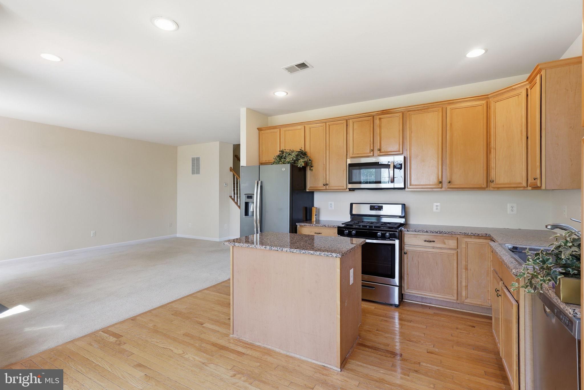 19617 Edgemont Square Ashburn, VA 20147 - Photo 19 of 65 a kitchen with stainless steel appliances granite countertop a refrigerator stove top oven and sink