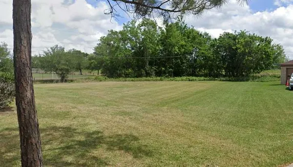a view of field with trees in background