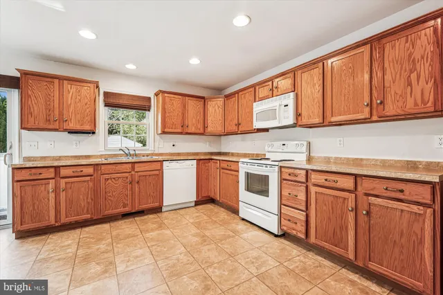 a kitchen with stainless steel appliances granite countertop a stove sink and cabinets