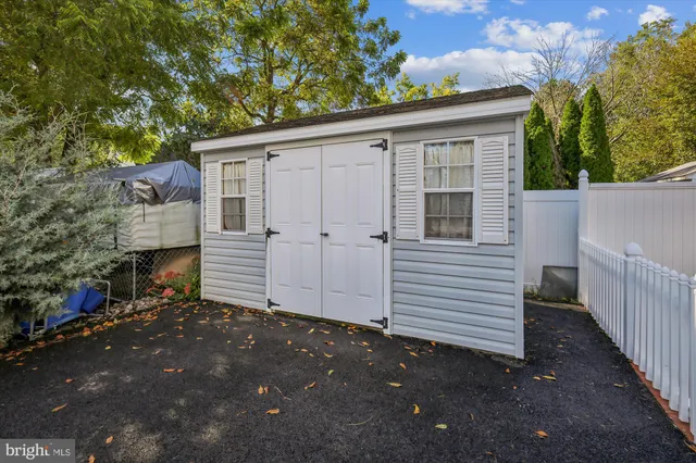 a view of a house with a small yard and wooden fence