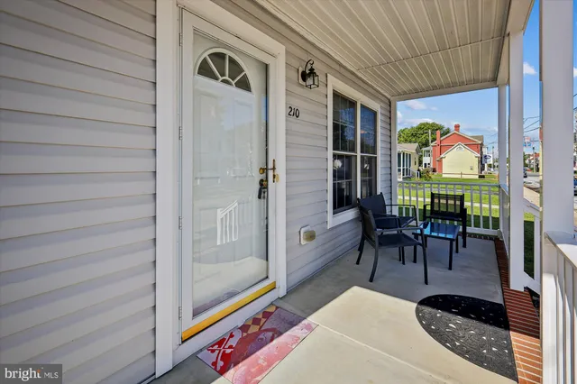 a view of a porch with chairs and potted plants