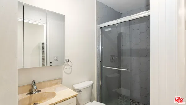 a bathroom with a shower a toilet and sink