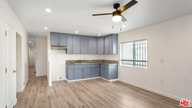 a kitchen with kitchen island granite countertop appliances cabinets a sink and a counter top space