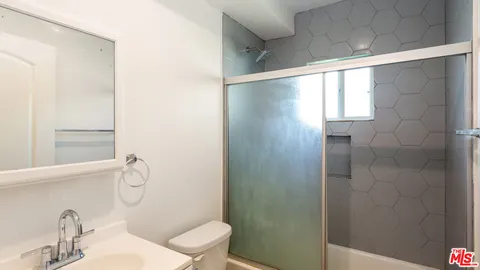 a bathroom with a sink and mirror with toilet