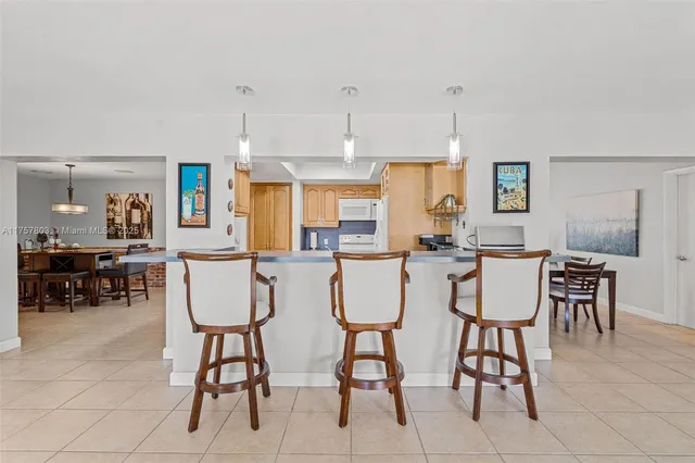 a dining room with chairs and a kitchen view