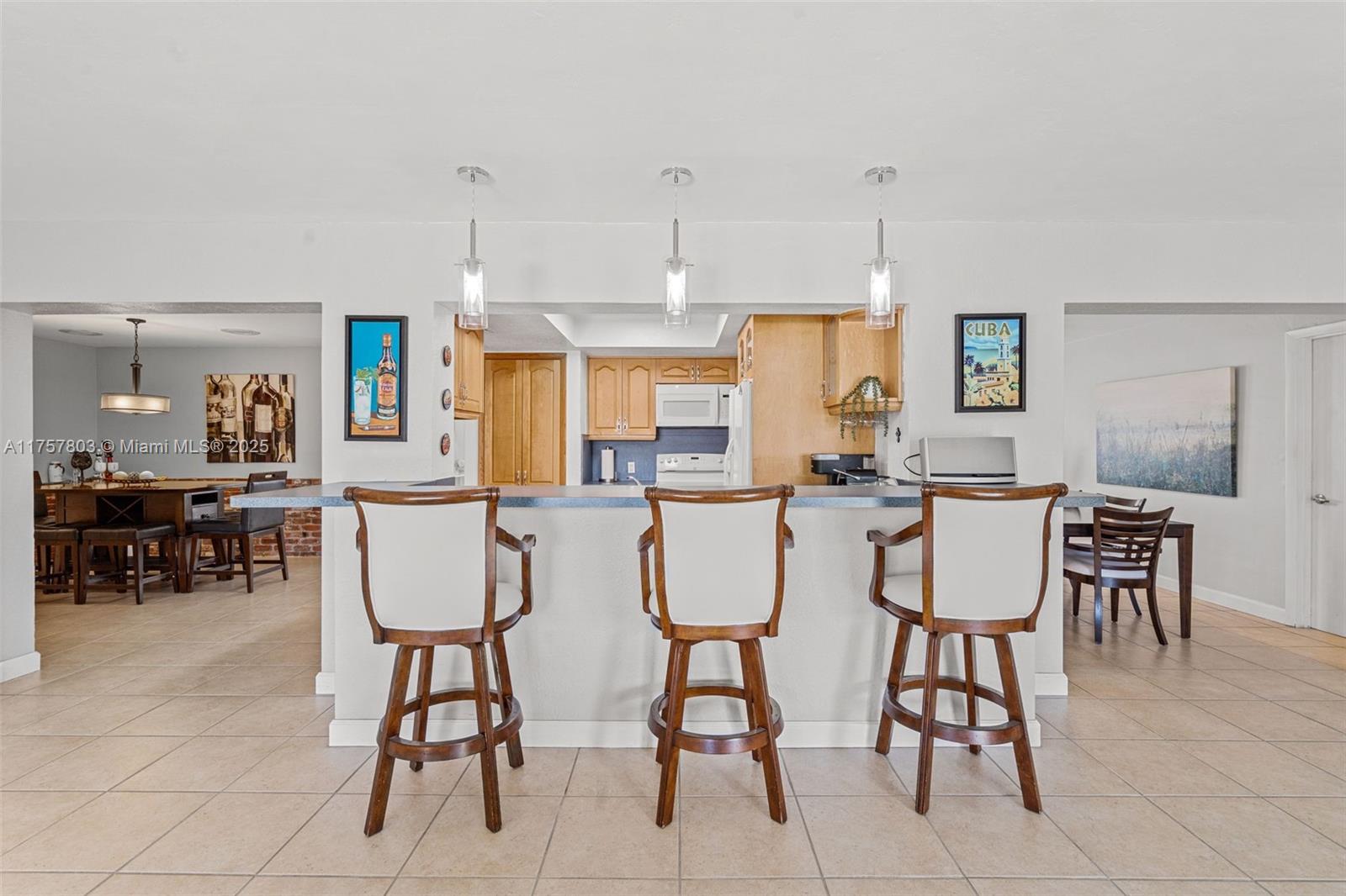 6311 Southwest 93rd Court Miami, FL 33173 - Photo 13 of 41 a dining room with chairs and a kitchen view